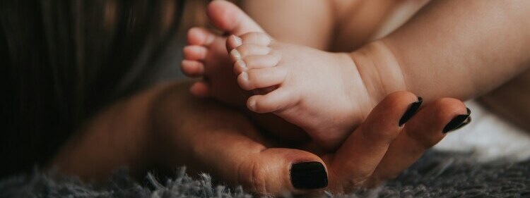 infant foot held dearly